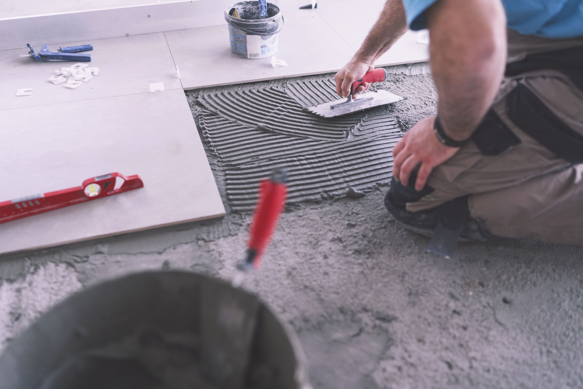 Man applying tile adhesive on the floor